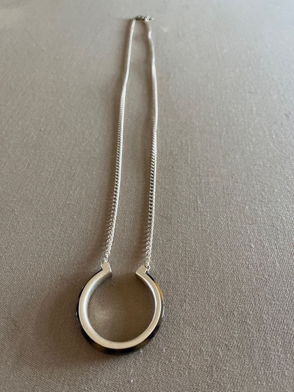 Express long gold chain with tortoise shell covered opened circle necklace.